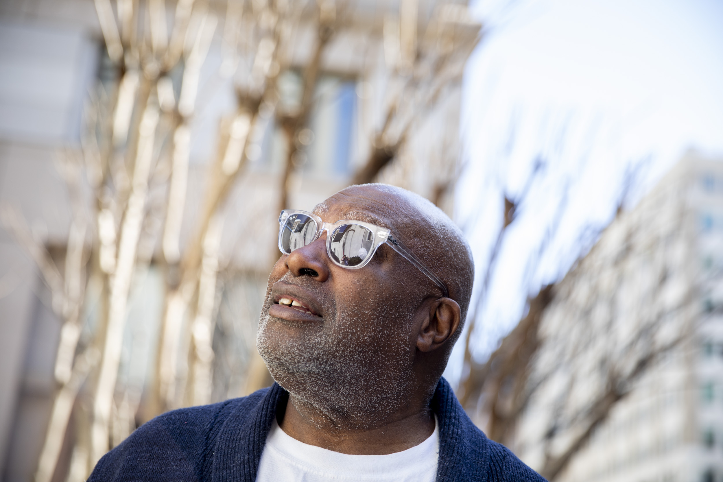 Photo of a man wearing sunglasses with his head turned toward the sky.
