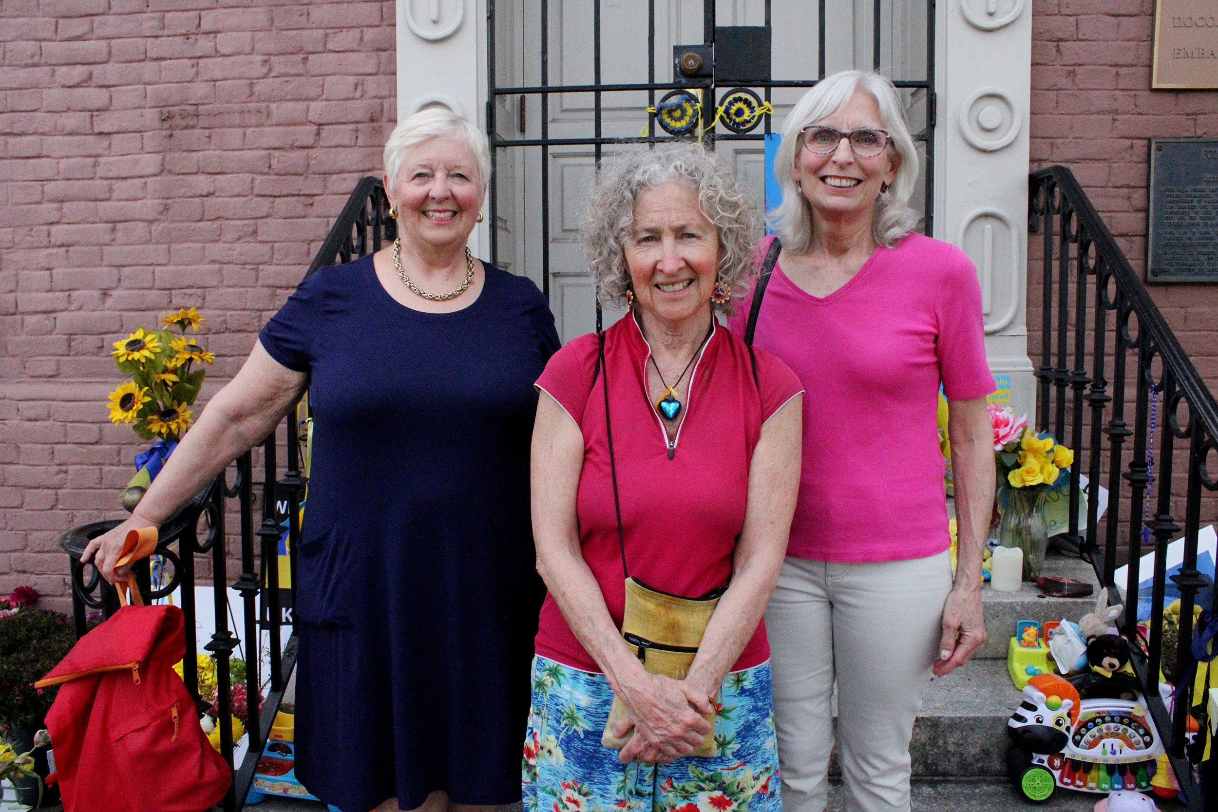 Photo of three women posing together in front of the stairs to the Embassy of Ukraine.