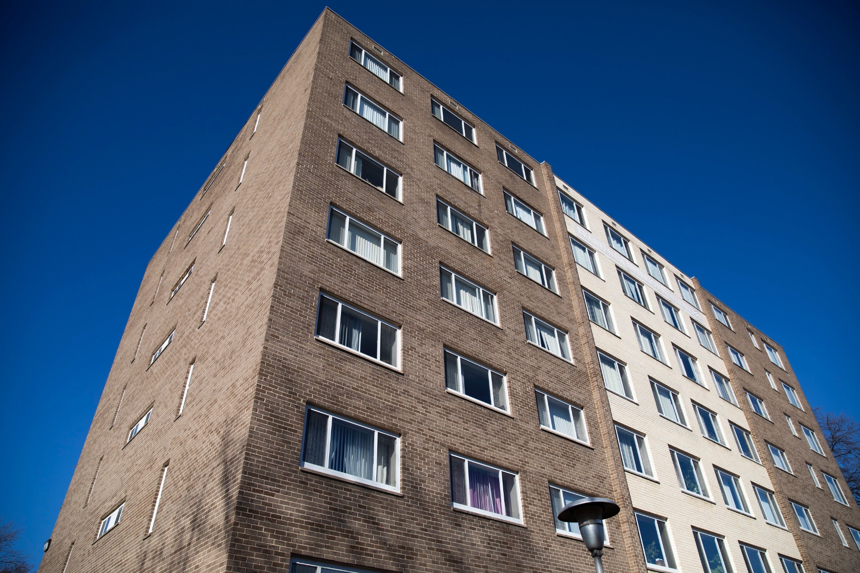 Photo of an apartment building with blue sky behind it.
