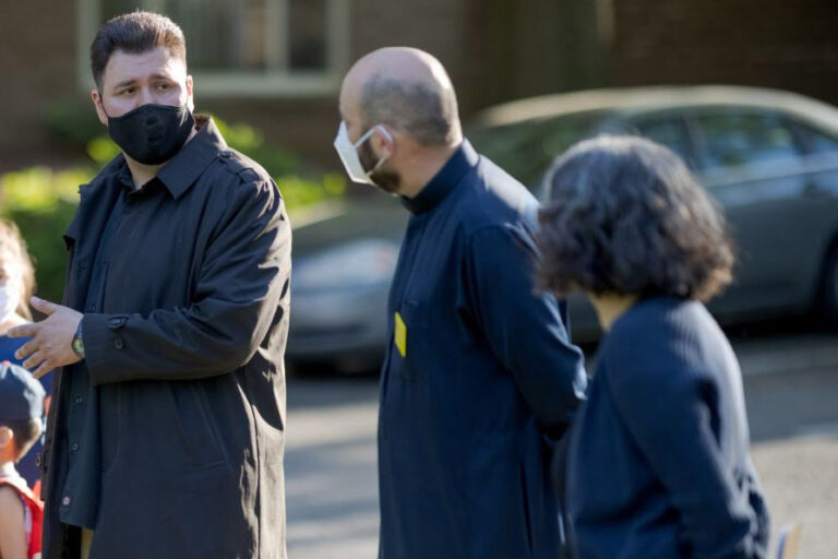Un foto de un hombre habla a otras personas
